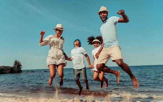 Family jumping in the surf on the beach