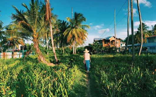 Guyana, lady walking through long grass