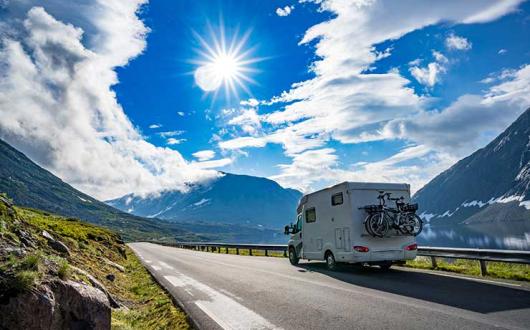 Motorhome driving by fjord in European alps