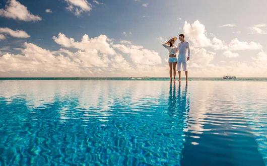 Couple standing by infinity pool