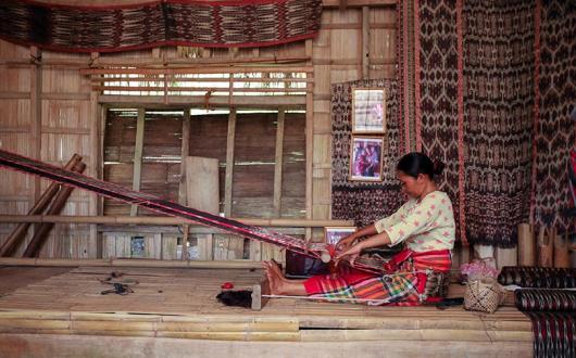 Filipina woman weaving on a loom