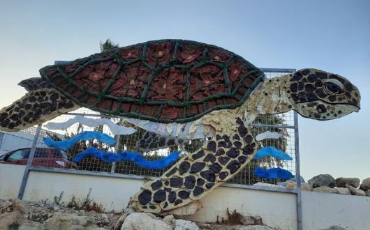 Made entirely from plastic waste, the turtle artwork, named "Calypso", is in a "prominent" position at Ayia Triada beach to raise awareness of the issue of plastic pollution