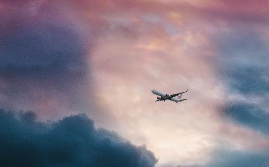 A plane emerges from stormy skies (Credit: Leio Mclaren/Unsplash)