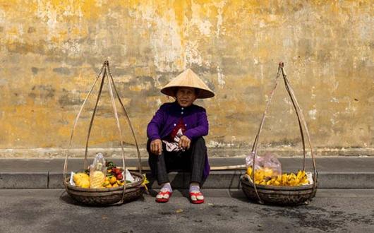 A fruit seller in the streets of Hoi An, where Just You’s Discover Vietnam itinerary visits community projects
