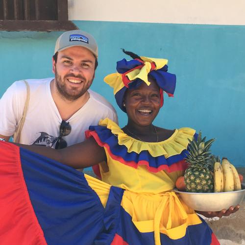 Charlie Thomas stands next to a Afro-Colombian woman wearing vibrant clothing