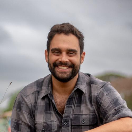 Man smiling in tartan shirt with mountain background 