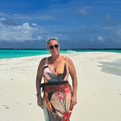 White woman smiling on sandy beach in the Maldives 