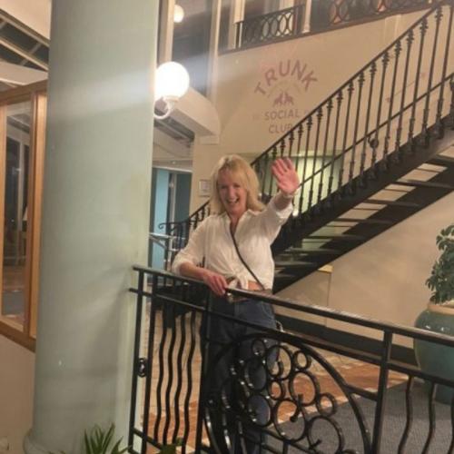Woman with blonde hair smiling by balcony