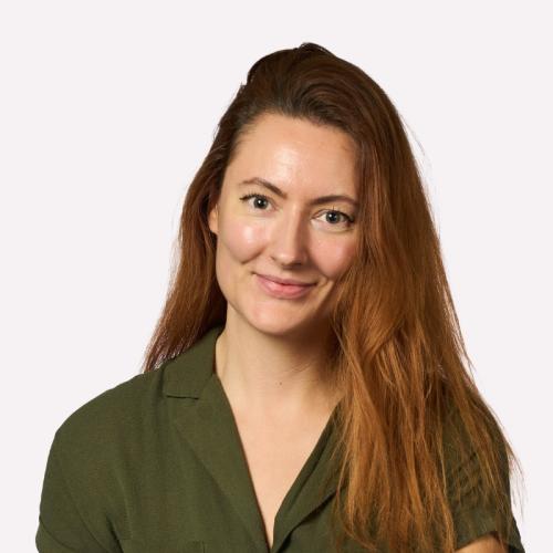Professional head shot of young white woman with long red hair and green dress 