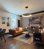 Cozy sitting room with brown couches and wooden dining set 