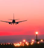 An aircraft coming in to land at sunset