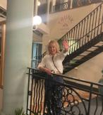 Woman with blonde hair smiling by balcony