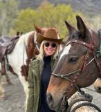 Blonde woman smiling with horse