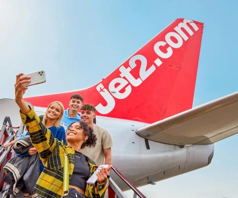 Young Jet2 customers take a selfie as they board one of the airline and operator's aircraft