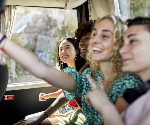 Young people taking a selfie while travelling on a coach