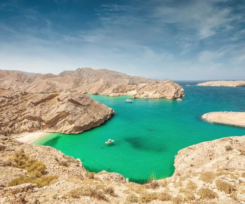 View of mountainous coastline surrounding a turquoise lagoon