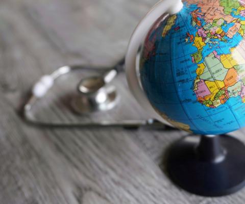A stethoscope pictured next to a globe
