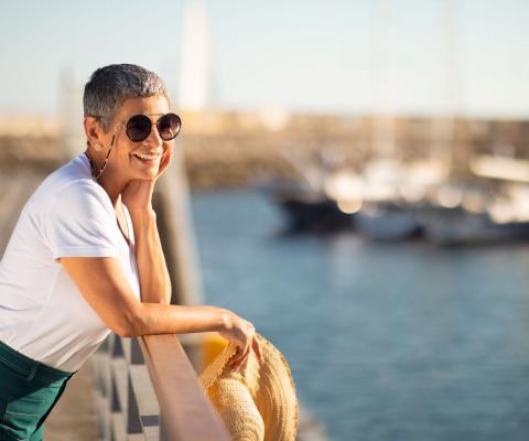 A female solo travellers looks out to sea from a harbour