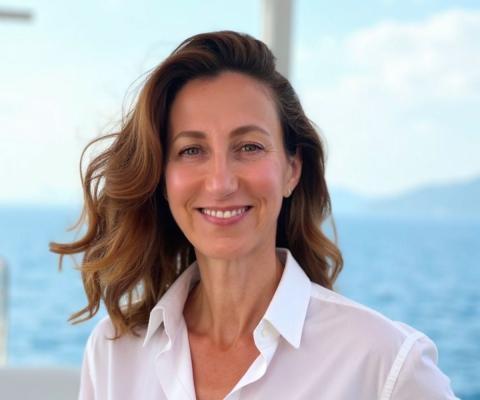 Smiling middle-aged woman with long brown hair and a white shirt 