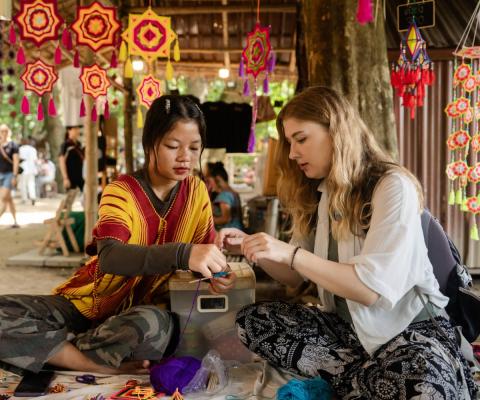 A tourist takes part in a craft workshop with a local guide
