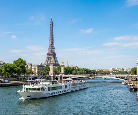 Trafalgar river cruise ship sailing along the Seine on a sunny day, with the Eiffel Tower in the background