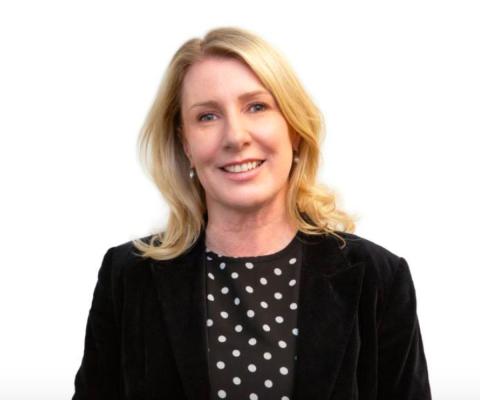 Blonde woman in black suit smiling