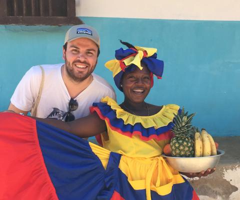 Charlie Thomas stands next to a Afro-Colombian woman wearing vibrant clothing