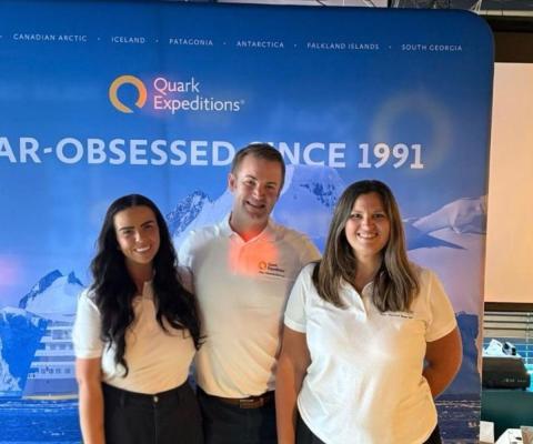 Three people smiling, two women and one man, wearing white t-shirts 