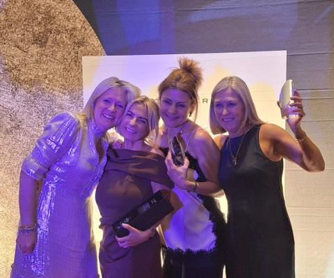 Four smiling women at an awards show 