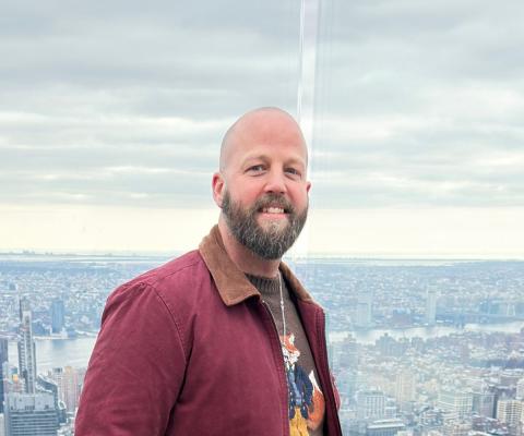 Man smiling with New York City background