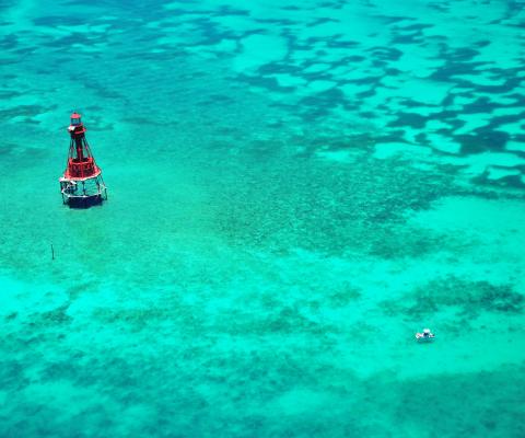 Lighthouse in the middle of turquoise blue ocean