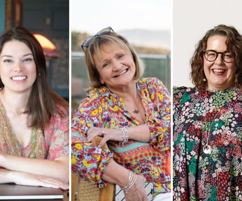 Three women smiling and wearing patterned dresses 