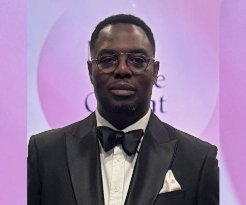 Black man wearing tuxedo, soft pink background 