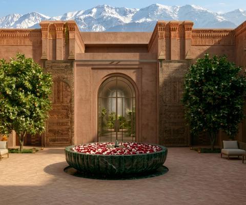 Sandstone grand hotel entrance with green trees and blue sky background