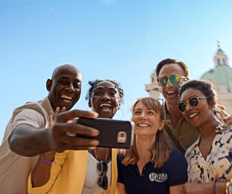 Group of people pose in front of landmark for a selfie