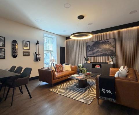 Cozy sitting room with brown couches and wooden dining set 