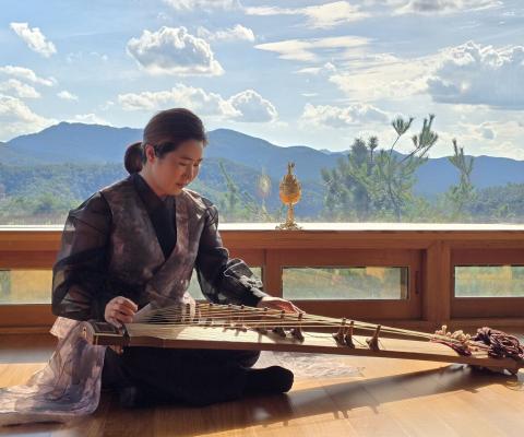 A lady plays a gayageum – a traditional Korean stringed instrument