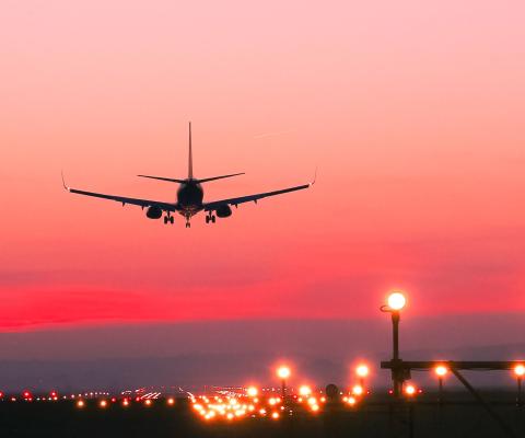 An aircraft coming in to land at sunset