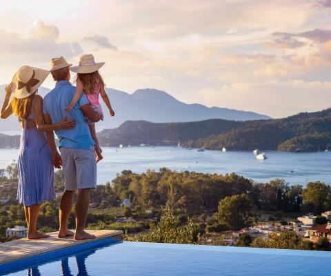 A family standing by the pool overlooking the coast