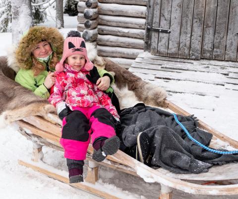 A family enjoy a sleigh ride in Lapland