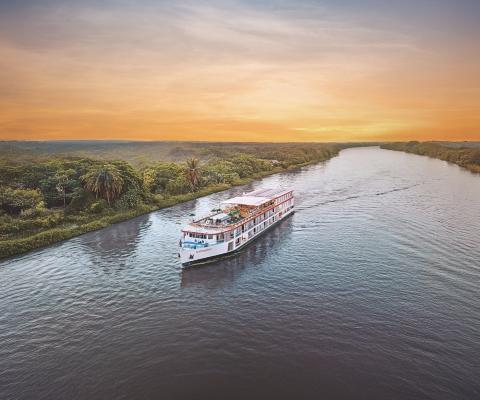 River cruise boat sails down Magdalena river during sunset