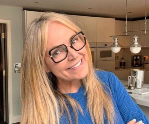 Woman smiling with blonde hair and glasses, her background is a modern kitchen