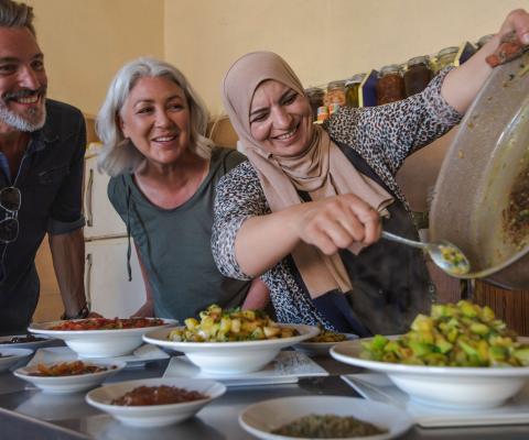 A local host welcomes a tourist couple of a cooking class