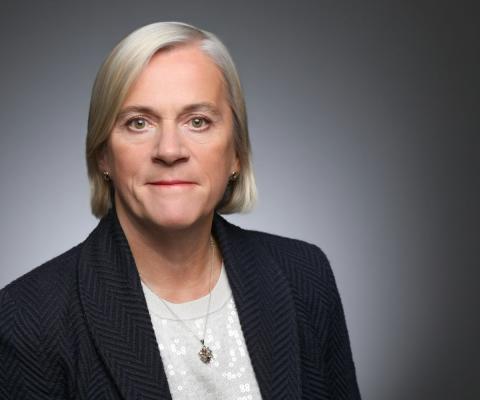 Headshot of middle-aged woman with short blonde hair wearing suit 