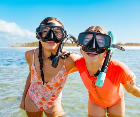 Young boy and girl in snorkels smiling at camera 