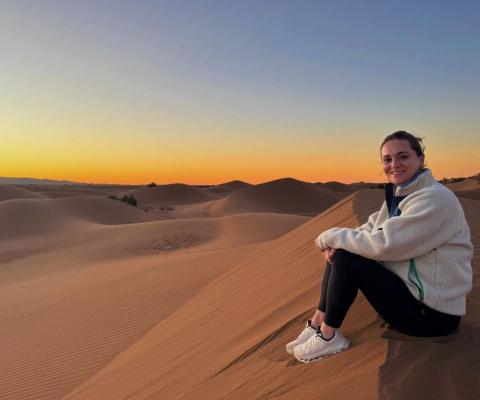 Travel agent Vanessa Good sitting on Sahara sands at sunrise