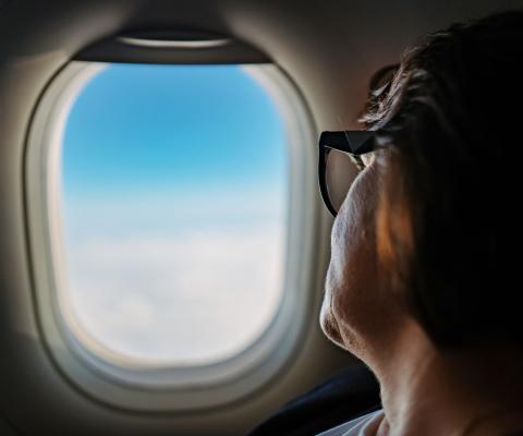 A passenger looks out the window of an aircraft
