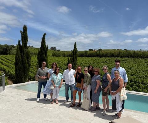 Group of travel agents standing and smiling by a private outdoor pool in rural Portugal 