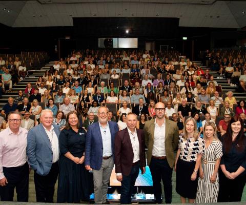 Large group of smiling people at work event 