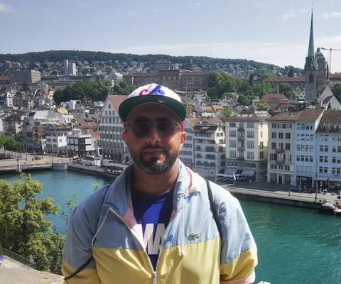 Man with sunglasses and hat in front of river in Europe